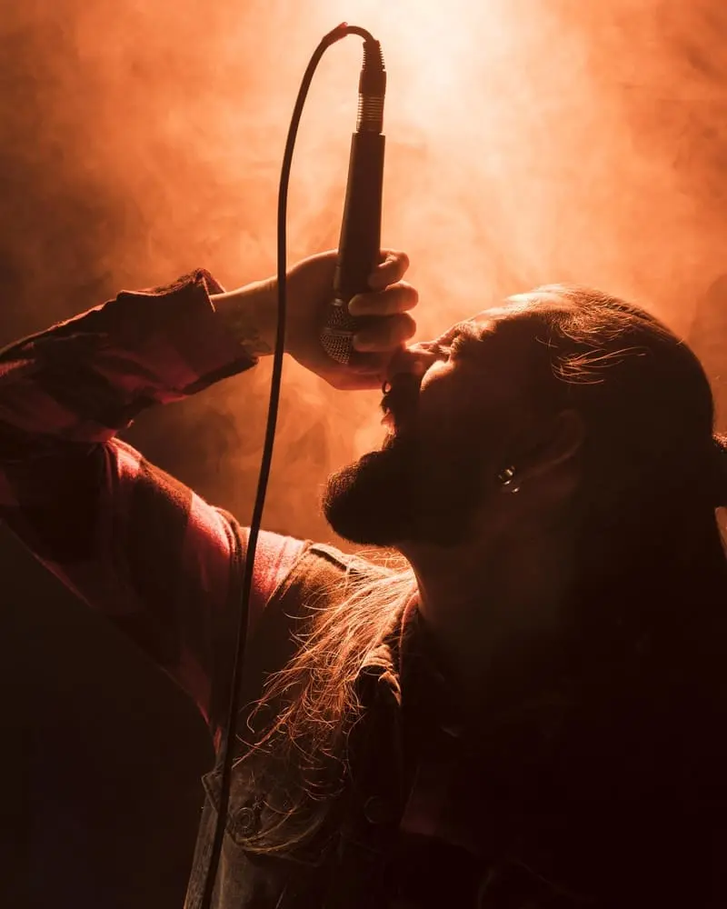 side-view-person-holding-microphone-sings (1)
